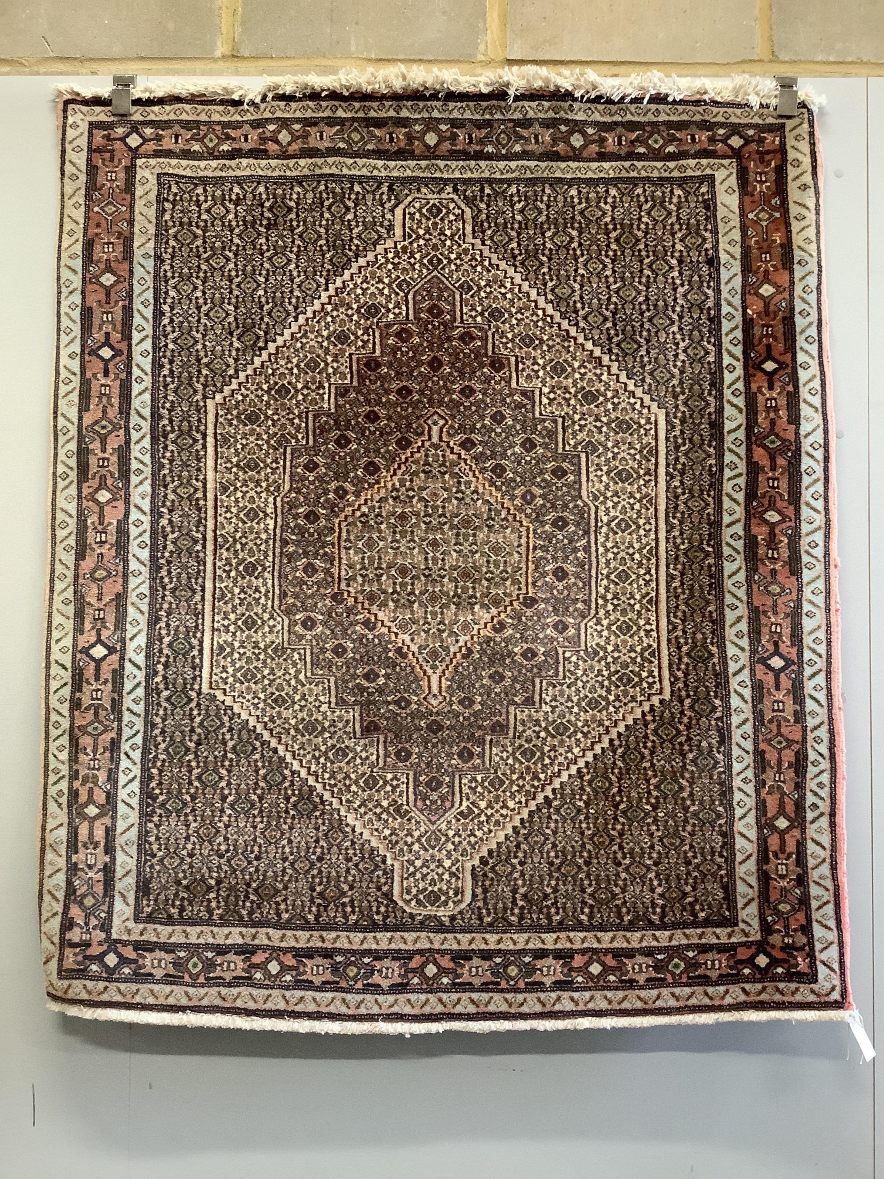 A North West Persian ivory ground rug, 150cm x 128cm. Condition - fair